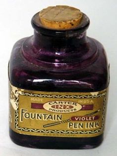 a bottle of fountain violet ink on a white surface with a corked top and label