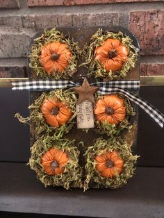 an arrangement of pumpkins in the shape of a snowman with moss on it