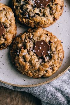 three chocolate chip cookies on a white plate