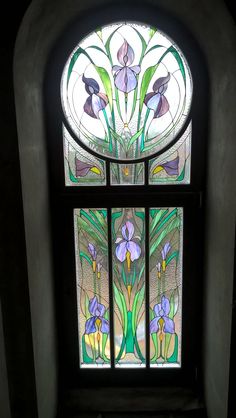 a stained glass window with purple flowers on it