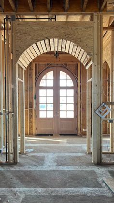 the inside of a building under construction with an arched door and window frame in place