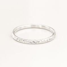 a white gold wedding band with small flowers on it