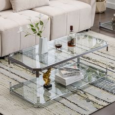 a glass coffee table sitting on top of a rug