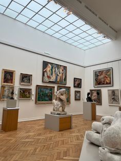 an art gallery with sculptures and paintings on the walls