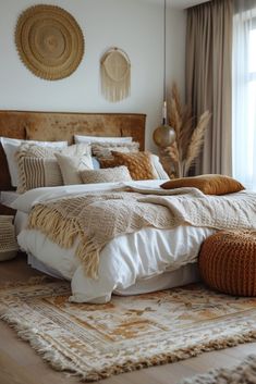 a large bed sitting in a bedroom next to a window with lots of pillows and blankets on top of it