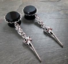 "This awesome pair of 3/4\" (19mm) dangle plugs feature beveled edge black glass gems, set on silver plated frames atop black plugs. Dangling from each are Byzantine chainmaille segments, crafted using ultra shiny, lightweight bright aluminum rings. Finishing off each plug is your choice of silver plated charm. **Note that the ankh charms have more of a matte finish than the other charms.** Plug Size: 3/4\" (19mm) Top of Gem to Back of Plug: 3/4\" Total Length from Top to Bottom: 3 1/2\" Plug Ch Wedding Gauges, Byzantine Chainmaille, Dangle Plugs, Earrings Gothic, Crow Skull, Plug Earrings, Alternative Bridal, Plugs Earrings, Glass Gems