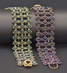 two beaded bracelets sitting next to each other on a black surface and one has a gold clasp