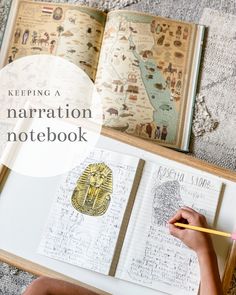 an open notebook with the words keeping a narration notebook written on it and a child's hand holding a pencil