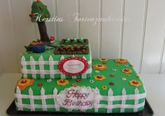 a green birthday cake with trees and flowers on it