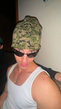 a man wearing sunglasses and a camo hat