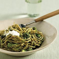 a bowl filled with pasta and broccoli on top of a table