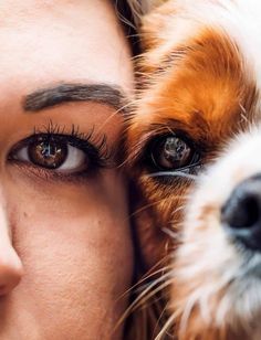 a close up of a woman with her dog's face next to her eyes