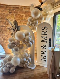 an arch with balloons attached to it in front of a window