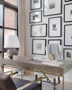 a living room with pictures on the wall and a table in front of a window