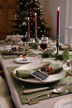 a table set for christmas dinner with place settings