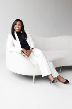 a woman sitting on top of a white couch