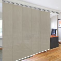 an empty room with a desk and chair in front of a sliding glass door that is partially open