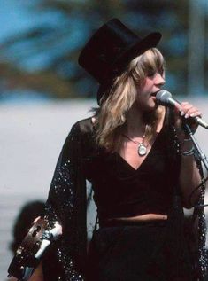 a woman wearing a top hat and holding a microphone