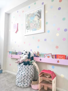 a child's room with polka dot wallpaper and toys on the shelf above