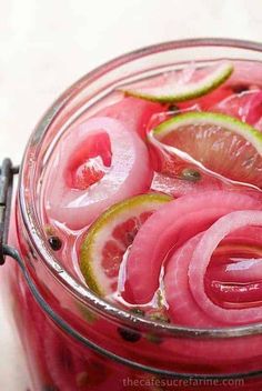 a jar filled with pink liquid and sliced fruit