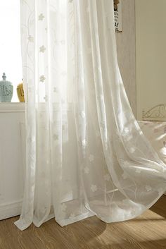 a white curtain hanging in front of a window