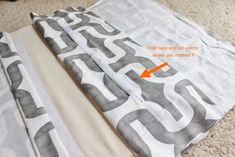 two pieces of fabric laying on the floor with an orange arrow pointing to it's center