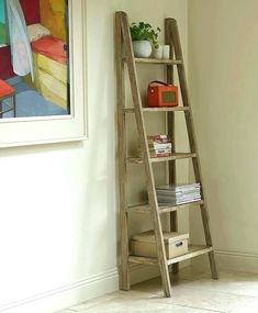 a wooden ladder leaning against a wall next to a shelf with books and magazines on it