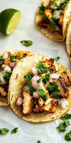 three tacos with chicken, onions and cilantro