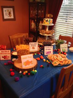 a blue table topped with lots of cookies and candy