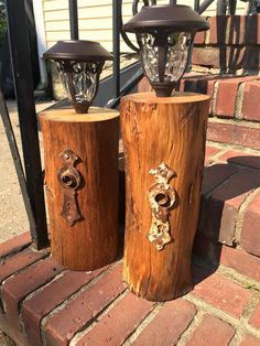 two wooden candlesticks sitting next to each other on top of a brick walkway