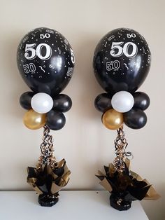 two black and white balloons are on top of each other, with the number 50 attached to them