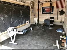 an empty gym with chalkboard and exercise equipment