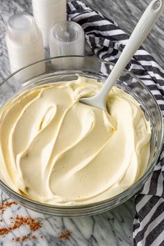 a glass bowl filled with cream on top of a table