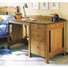 a wooden desk sitting in the middle of a bedroom