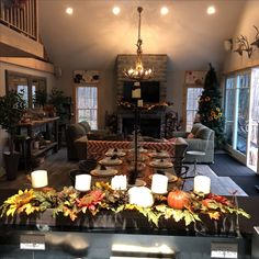 a living room filled with lots of furniture and candles on top of a coffee table