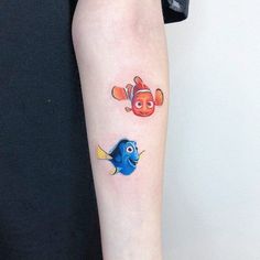 a small tattoo on the arm of a person with an orange fish and clown face