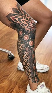 a person with a tattoo on their leg and legs is standing in front of a wooden floor