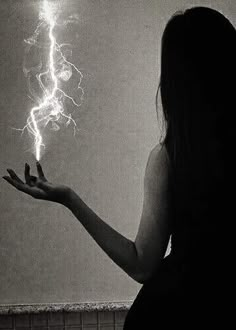 a woman is holding out her hand with a lightning bolt in the air above her