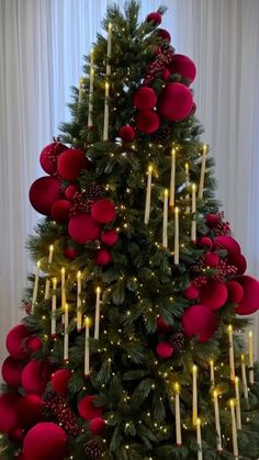 a christmas tree decorated with red balls and candles