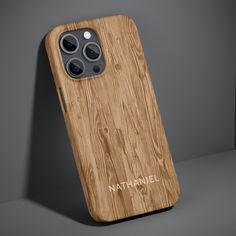 an iphone case made out of wood with the name nathan on it and two cameras