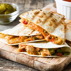 three quesadillas stacked on top of each other with peppers and chicken in the middle