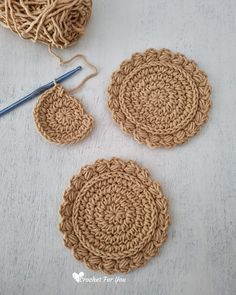 three crocheted coasters with yarn next to them