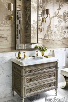 a bathroom with a sink, mirror and wallpapered walls in gold color scheme