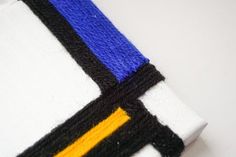 a white shirt with blue, yellow and black stripes on the chest is folded up