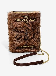 the monster book purse is brown and has a chain around it's neck, with an attached strap