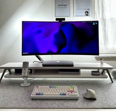 a computer monitor sitting on top of a white desk next to a keyboard and mouse