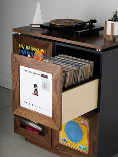 a record player is sitting on top of an entertainment center with records and vinyls