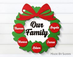 a christmas wreath with the words our family in red and green, hanging on a white wall