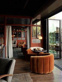 a living room filled with furniture and lots of windows next to a wooden flooring