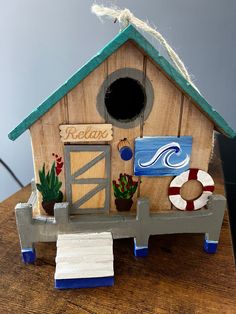 a bird house with a life preserver and succulents on the side